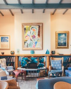 Modern fireplace in Glasgow with light wood and iron exterior mantel with interior blue and yellow fibreglass with fragmented design