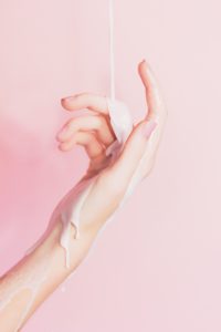 woman's hand covered in lotion as rejuvenating skin treatment under the umbrella of plastic surgery in Glasgow